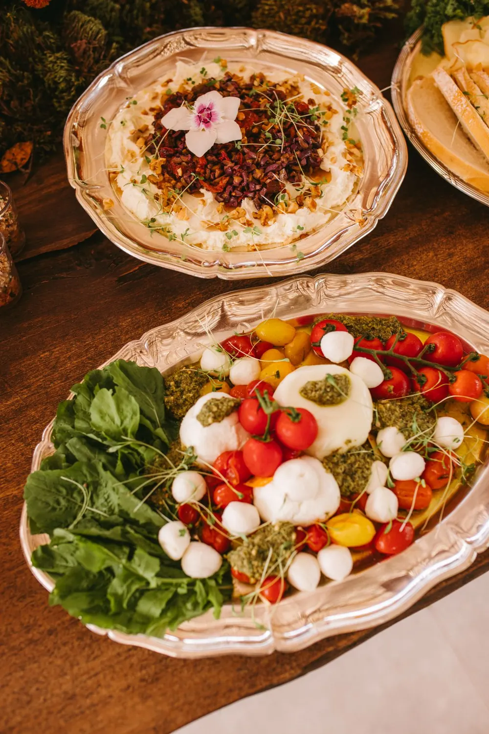 Two sharing platters: burrata salad and a grain dish with edible flowers
