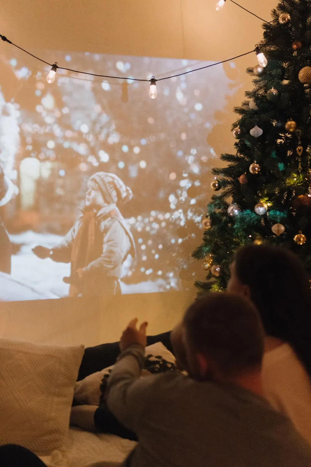 Couple on a sofa watching a film projected on the wall