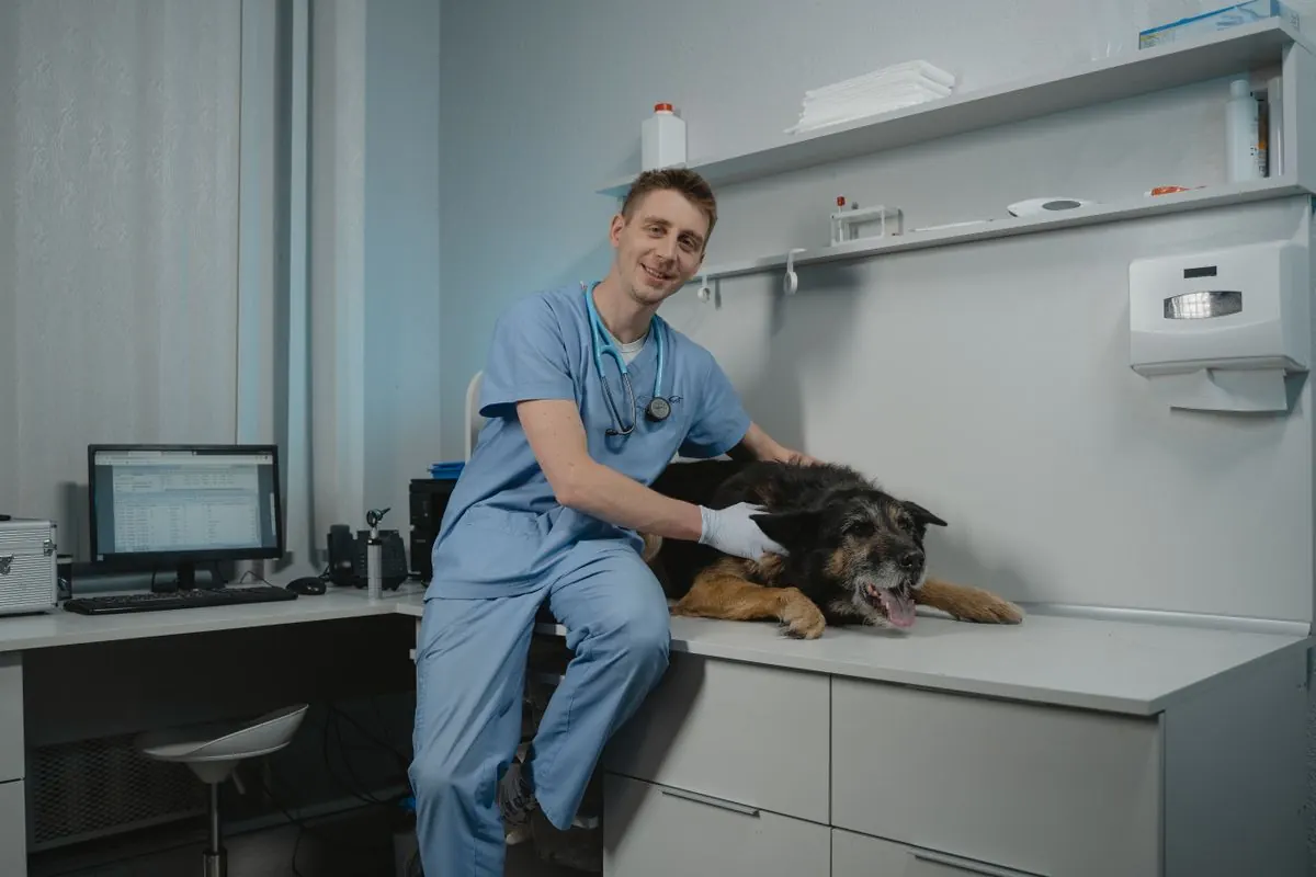 Smiling vet sitting with a black dog in a consulting room